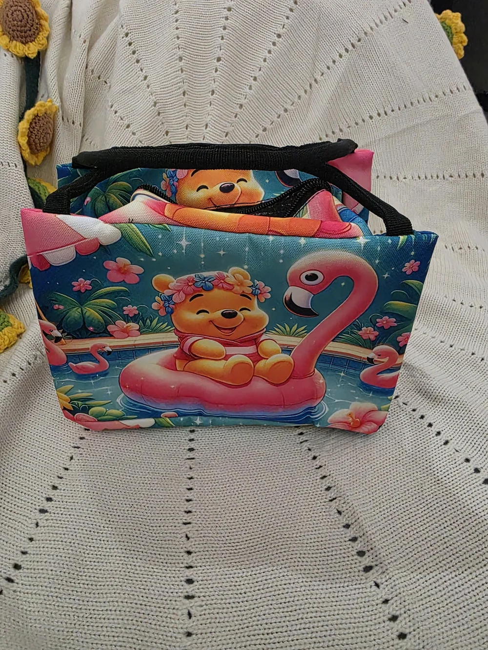 Insulated lunch bag features a playful design of Winnie the Pooh wearing a color